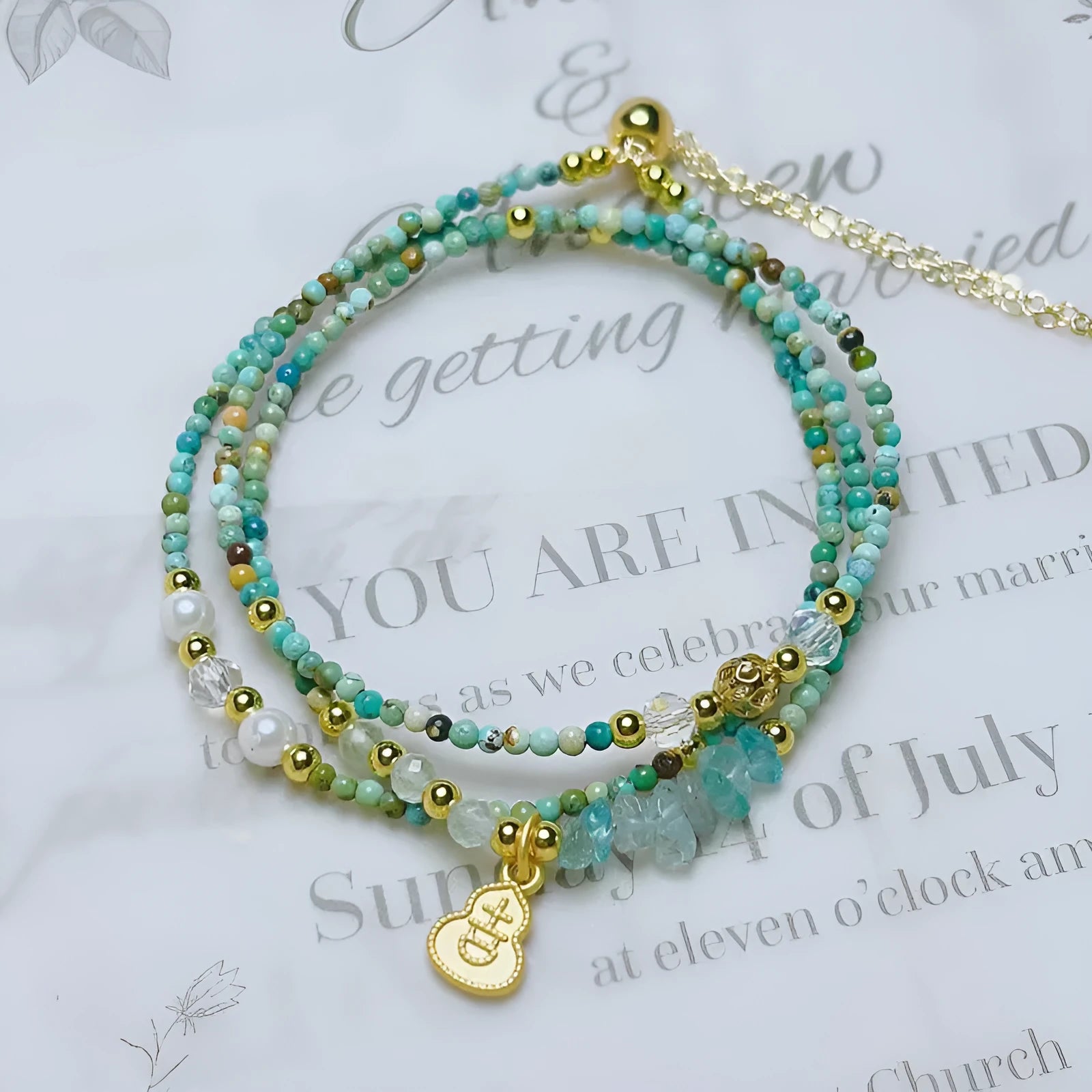 Xiaomi turquoise round bead bracelet with a silver three-ring pull-out adjustable clasp on a wrist.