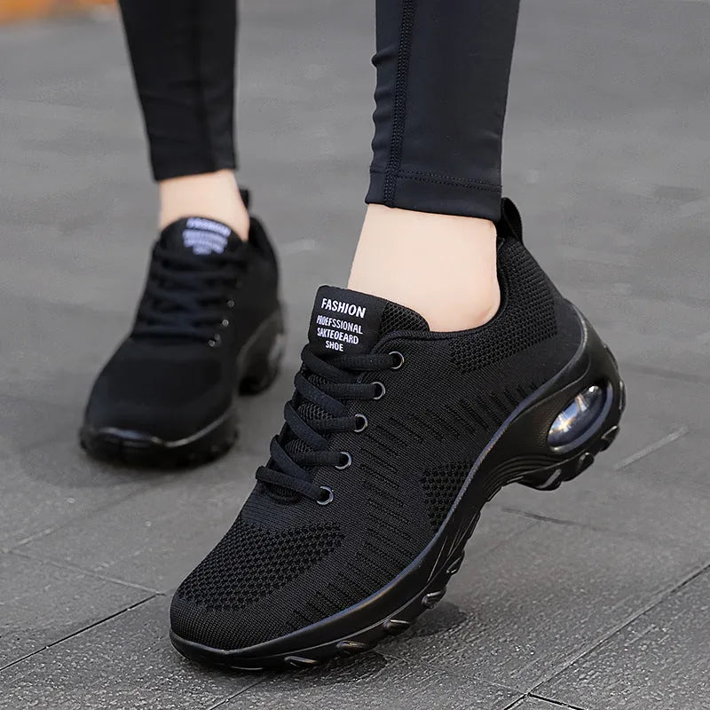 Red and black women's low-top mesh sneakers with round toe, front laces, and a mid heel on a white background.