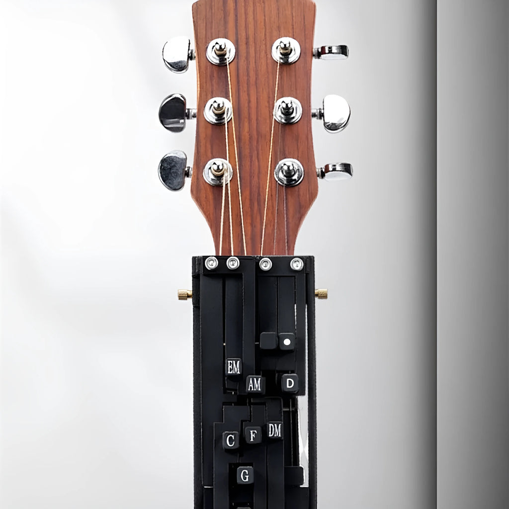 A black automatic chord maker device for guitar practice, shown next to an acoustic guitar.