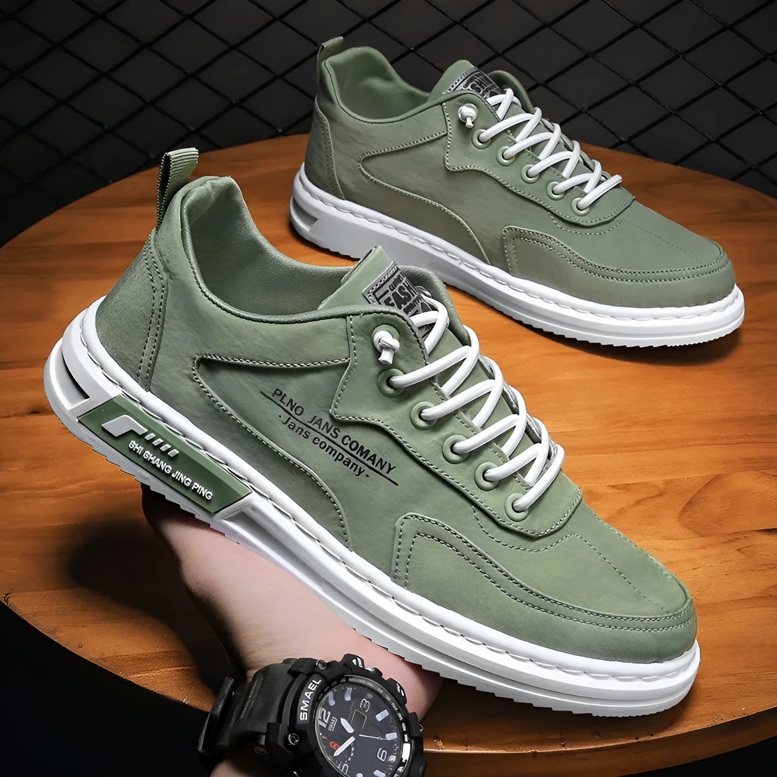 Men's green canvas lace-up sneakers with round toe, flat heel, and letter print side detail on a white background