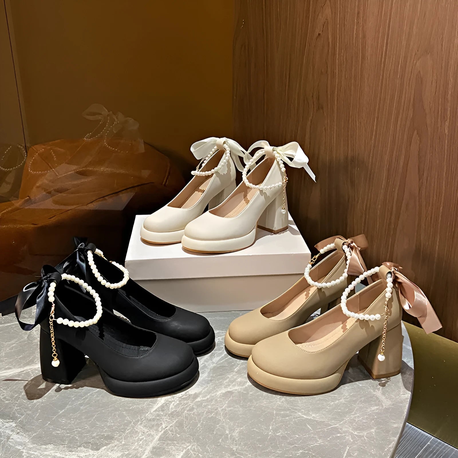 Women's beige Mary Jane shoes with chunky heel and silver ankle strap buckle on a wooden floor.