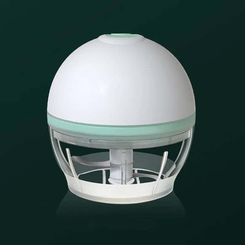 Portable electric mini garlic cutter with green body, transparent cup, and stainless steel blade on table