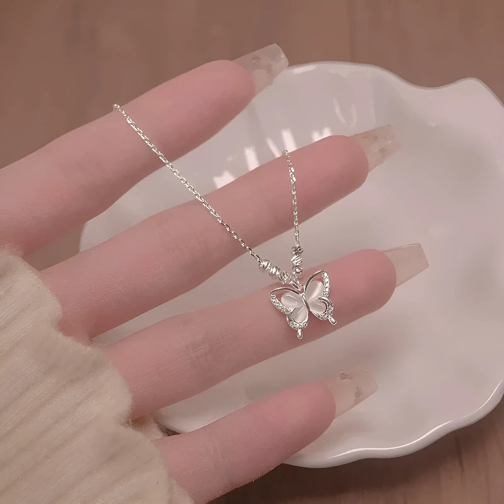 Silver women's butterfly necklace with opal pendant on a cross chain, shown adjusted to different lengths.