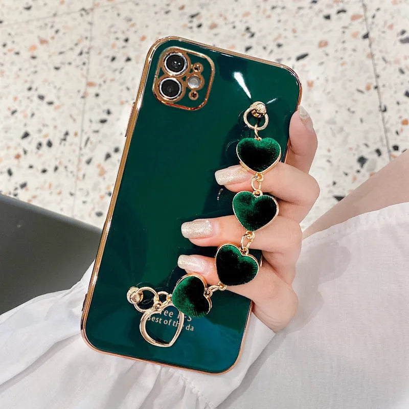 Solid colour silicone phone case with an integrated white protective bracelet on a table.