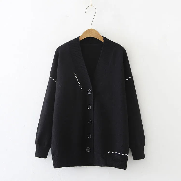 Women's loose black knitted cardigan coat with long sleeves on a hanger.