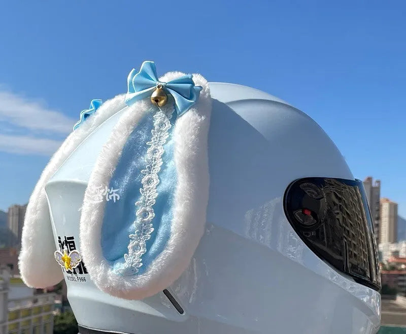 Carbon fibre rabbit ear decoration attached to a black motorcycle helmet, showing clip-on mechanism.