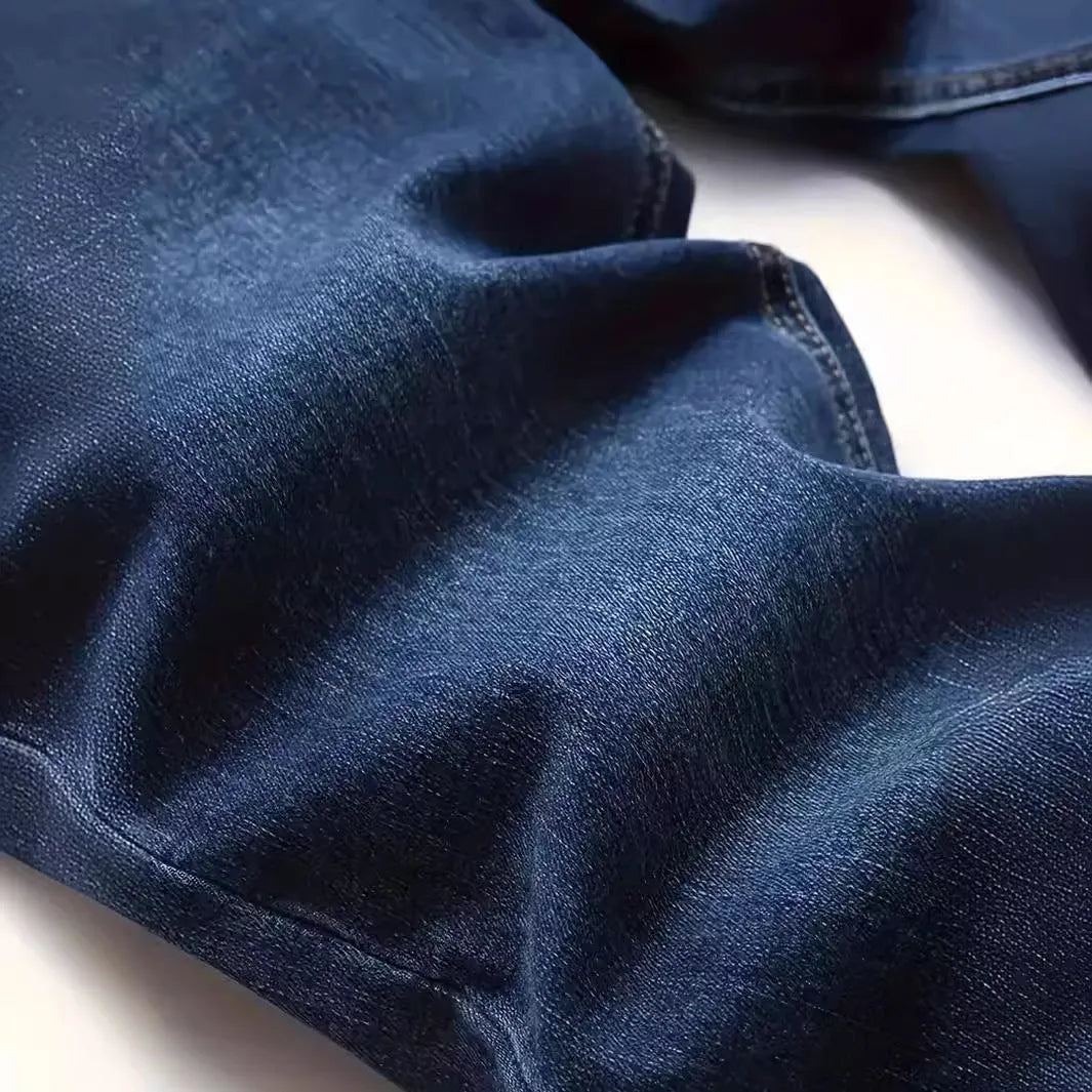 Men's dark blue skinny-fit cotton jeans with a mid-rise waist and zipper fly on a plain background.