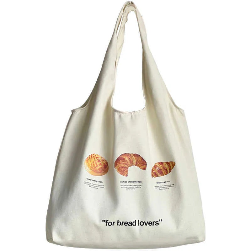 Beige canvas shoulder tote bag with a decorative bread and croissant print design.