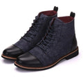Men's black leather motorcycle boots with metal buckle strap on shaft, shown on a wooden floor.