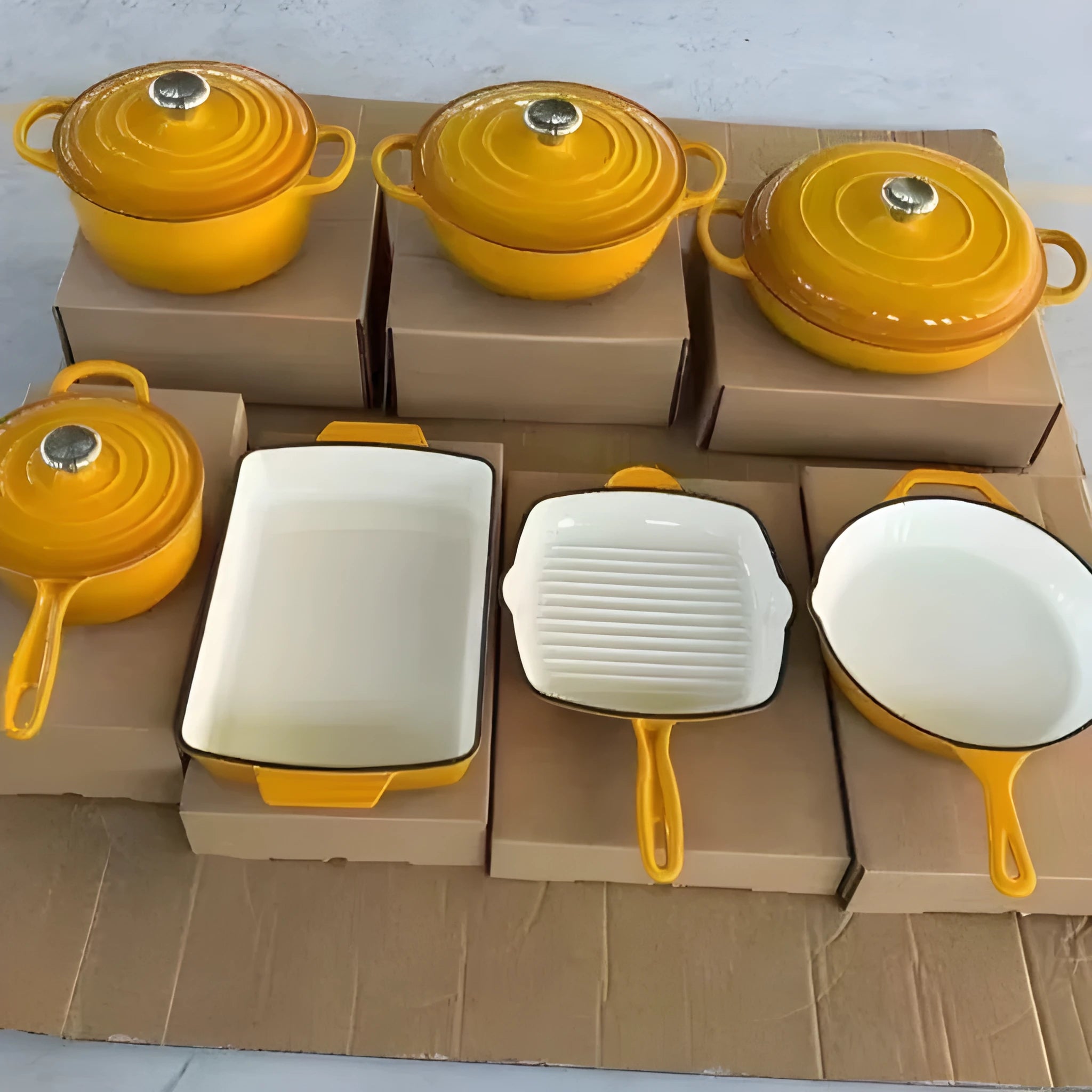 Cast iron enamel casserole set with frying pan and stew pot in light blue colour on a wooden table