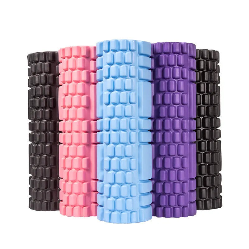 A solid black EVA foam roller on a gym floor, showing its cylindrical shape and texture.