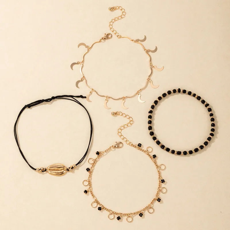 Women's gold tone alloy anklet set with hollow circles, shell beads, and black rice beads, four pieces