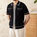 Slim black elastic knit polo shirt with a lapel collar and short sleeves on a hanger.