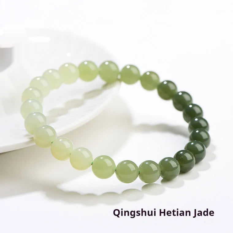 Natural clear water Hetian jade bracelet with round beads and barrel bead options on a wrist.