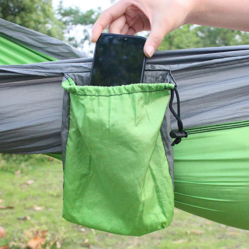 Blue parachute nylon camping hammock hung between two trees, showing its full 270cm length and 140cm width.