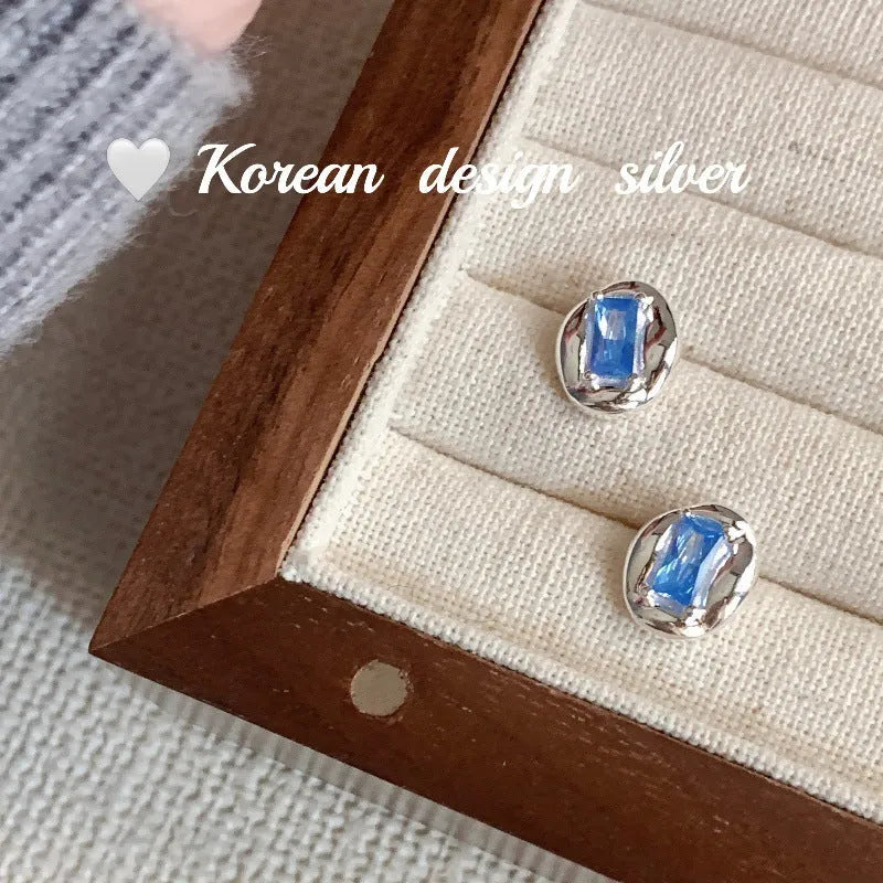 Sterling silver earrings with oval blue diamond in heart wire wrap setting
