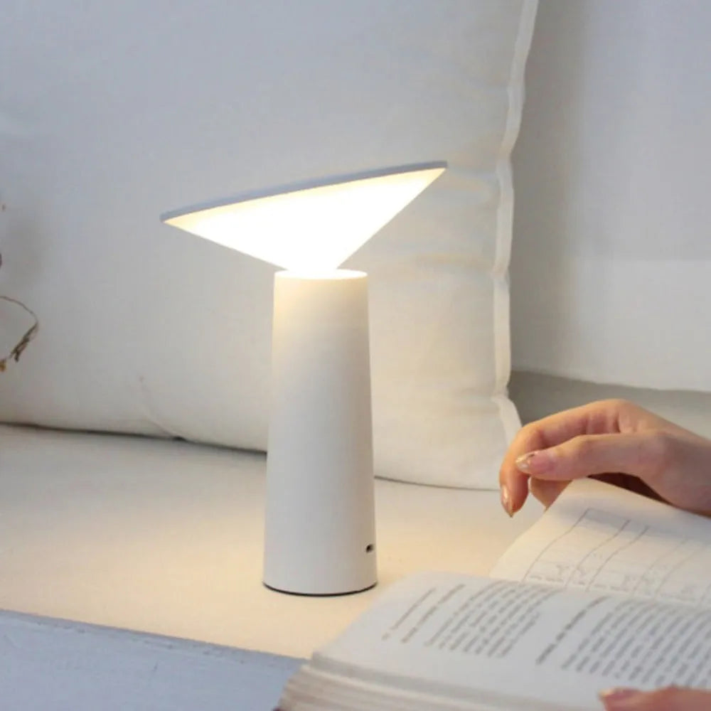 Black USB rechargeable LED desk lamp with touch sensor and adjustable lamp head on a wooden desk.