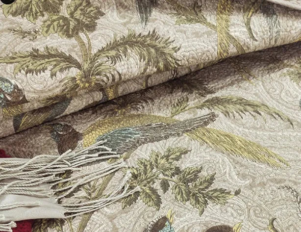 Blue American floral and bird pattern quilted cotton bedspread draped on a double bed