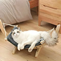 Grey solid wood cat hammock with canvas and velvet sleeping surface, hanging in a room