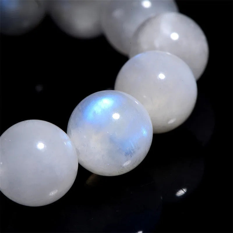 Natural blue and white polished moonstone round bead bracelet on a white background.