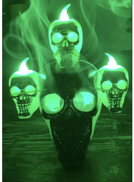 Golden skull ornament with LED light shaped like a skeleton hand holding a candle