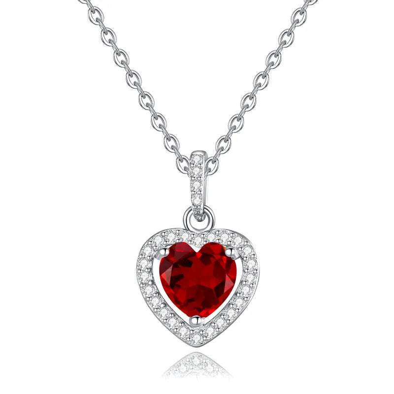 Women's sterling silver heart necklace with a natural gemstone on an adjustable cross chain.