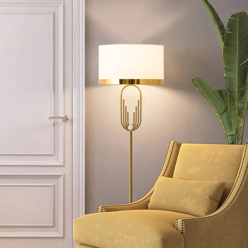 Modern silver floor lamp with adjustable height mechanism and fabric shade, remote control on side table