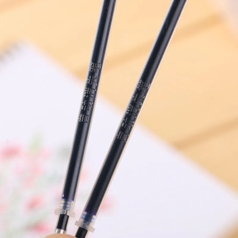 Automatic fade and disappear pen set showing pen holder, case, and eight refills on a notepad.