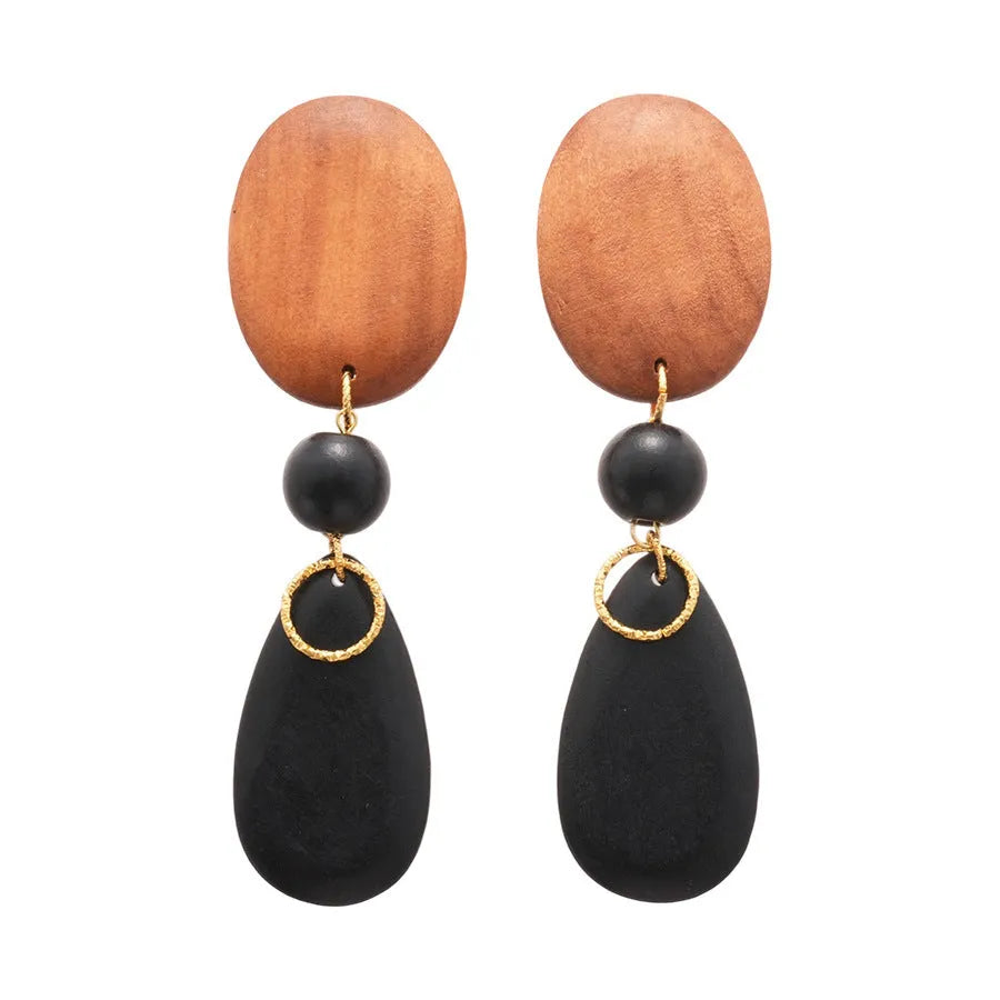 Wooden drop earrings with an ellipse shape in silver, brown, and black colours, showing manual craftsmanship.