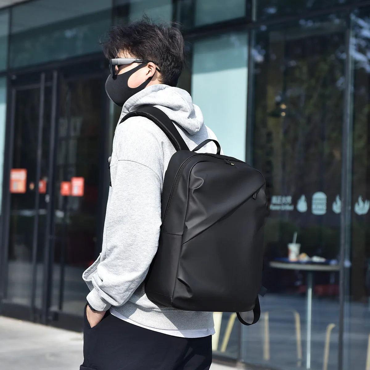 Men's large waterproof PU leather backpack in grey colour with visible stitching and laptop compartment.