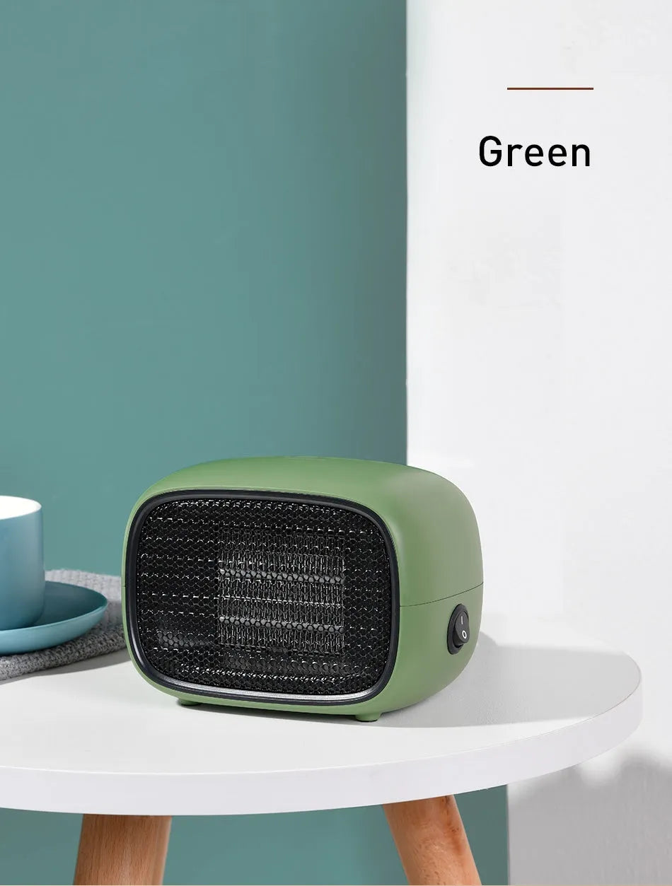 Small green portable ceramic fan heater on a desk showing its compact size.
