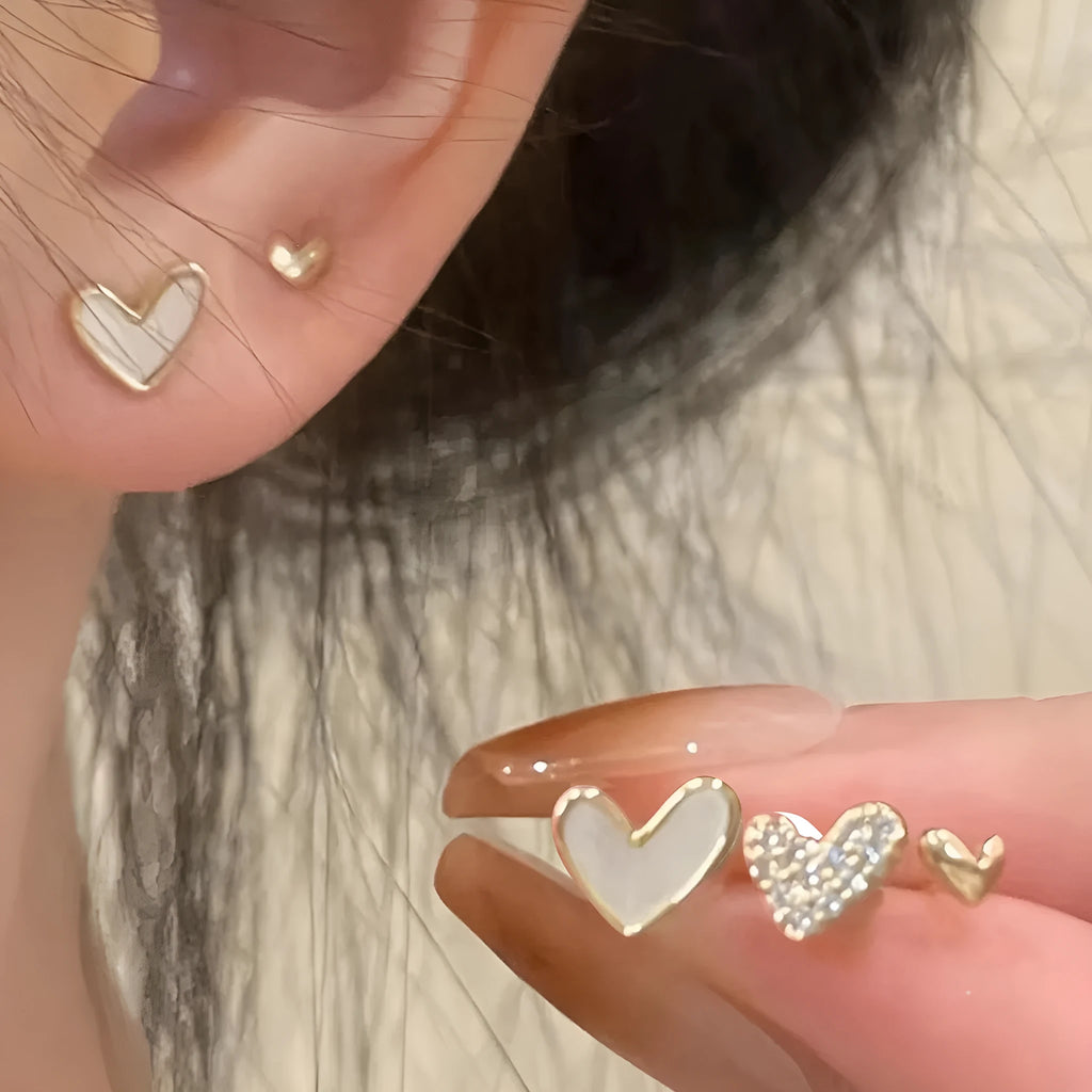 Set of three pairs of heart-shaped alloy earrings in gold, black, black and white, or pink colours