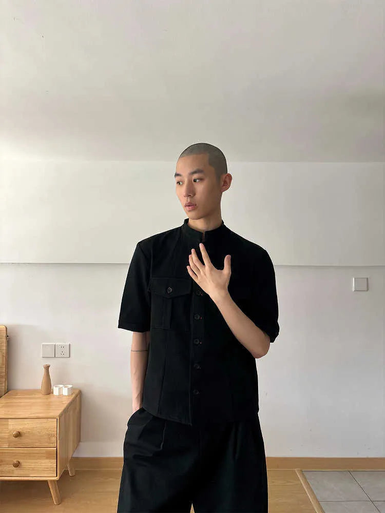 Handmade black loose fit half sleeve shirt with a shirt collar on a hanger.