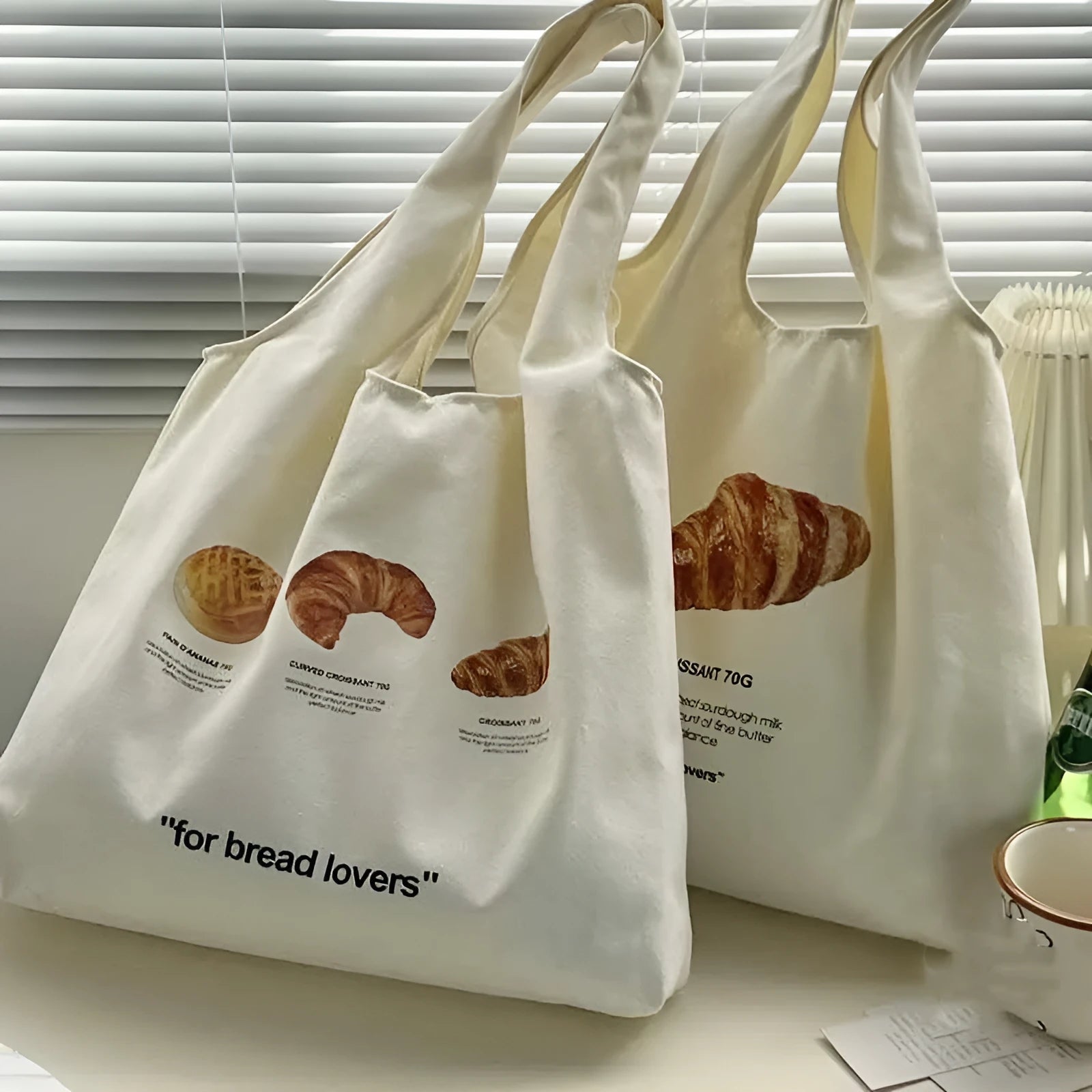 Beige canvas shoulder tote bag with a decorative bread and croissant print design.