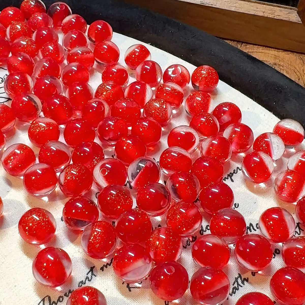 16mm round plastic scattered beads with glittering cat's eye effect in champagne colour, on a white background.