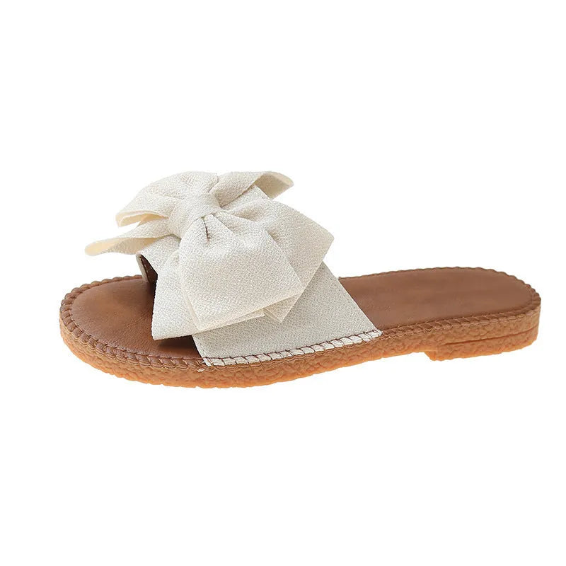 Women's beige suede slip-on sandals with a flat heel and soft bottom on a light background