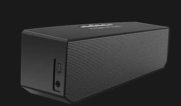 Black BS-6 Google Assistant Bluetooth smart speaker on a surface, showing its compact rectangular design.