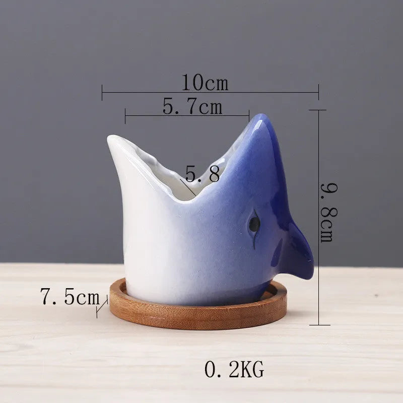 Blue ceramic cartoon succulent flowerpot with drainage hole on a desktop