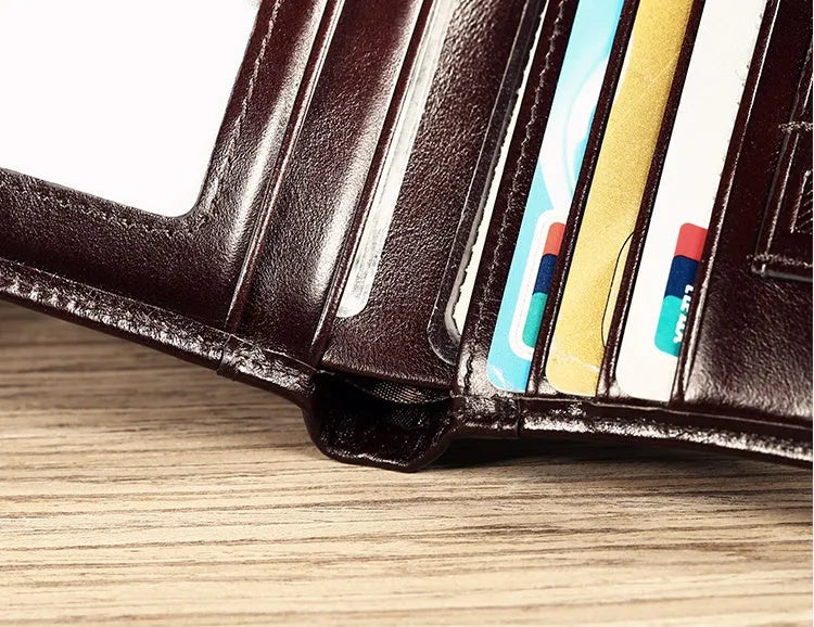 Men's black genuine leather bifold wallet open, showing eight card slots and a zipped coin compartment.