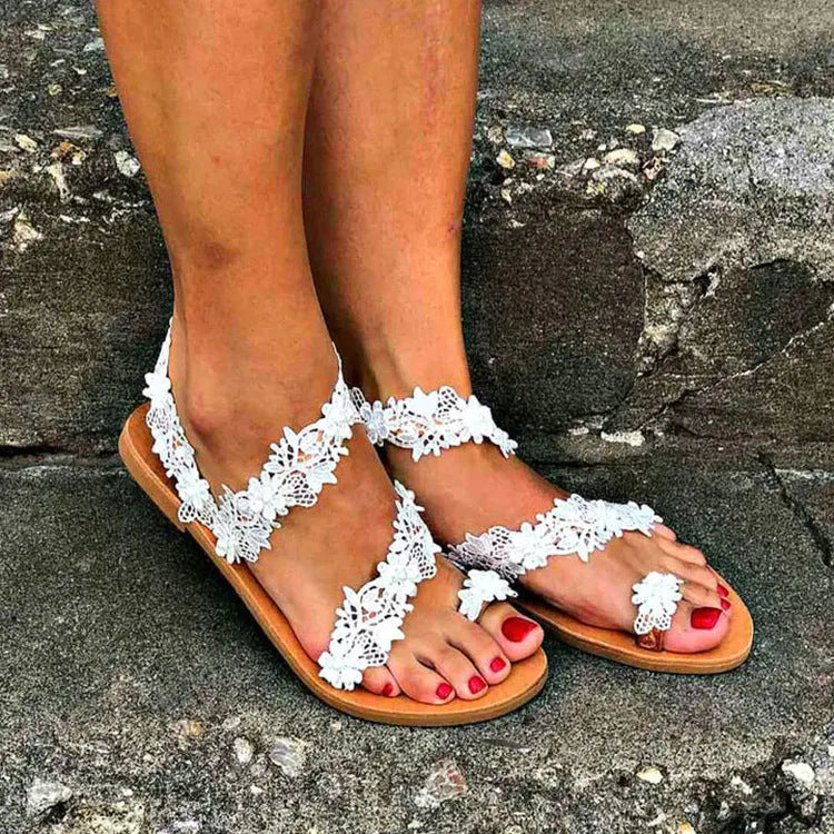 White plus-size women's flat shoes with rhinestone and floral decorations on patent leather.