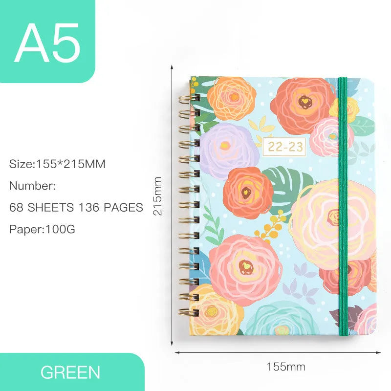 A5 spiral notebook with artistic cover design open to show lined pages