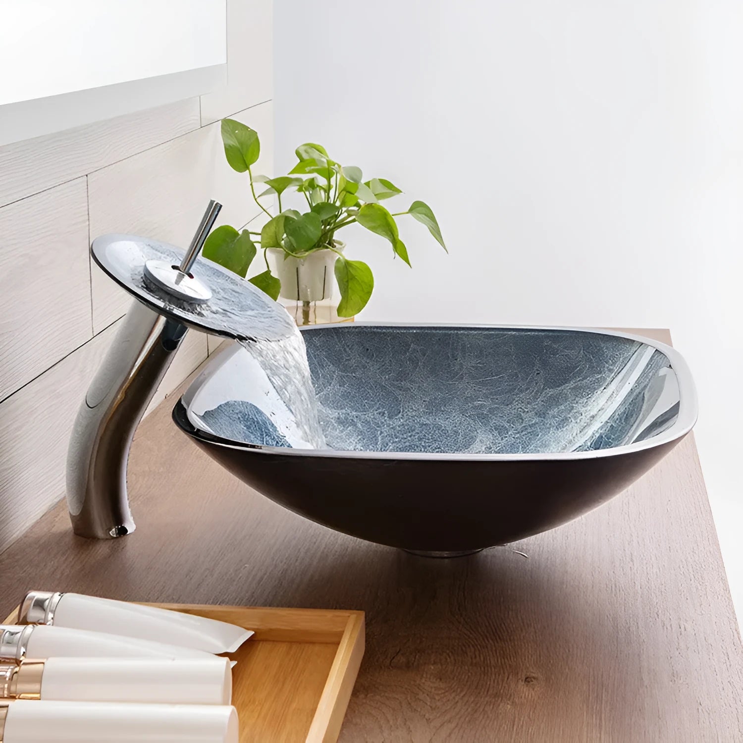 Blue grey coloured tempered glass bathroom table basin with simple art design on a countertop.