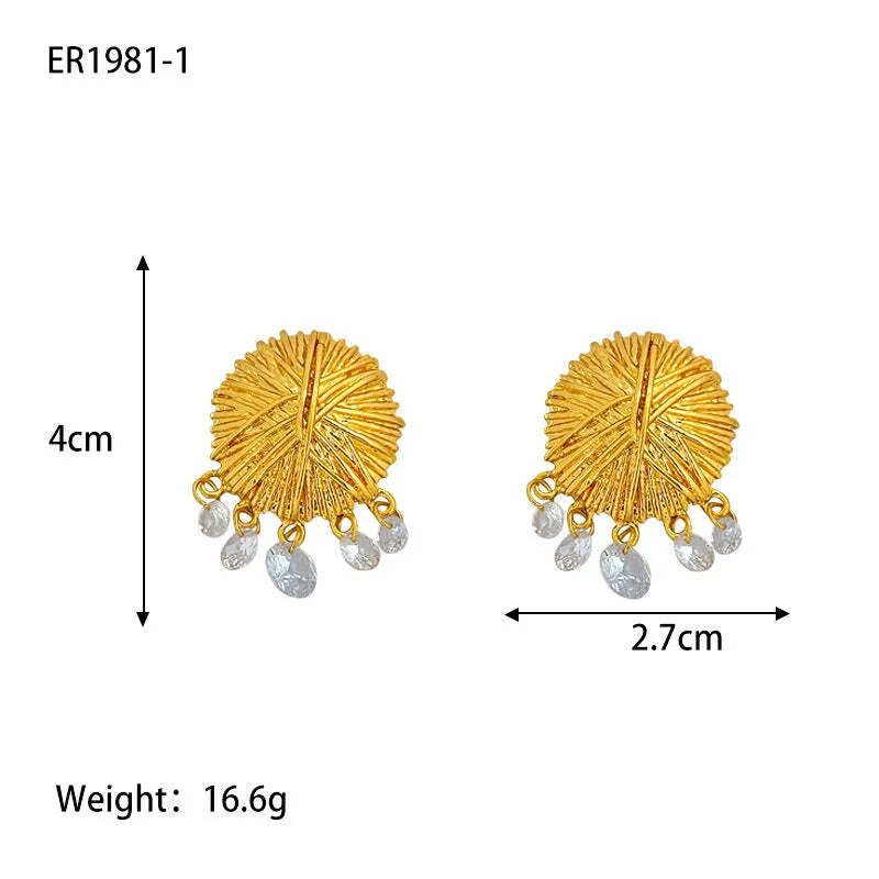 A pair of circular gold geometric hoop earrings on a plain background