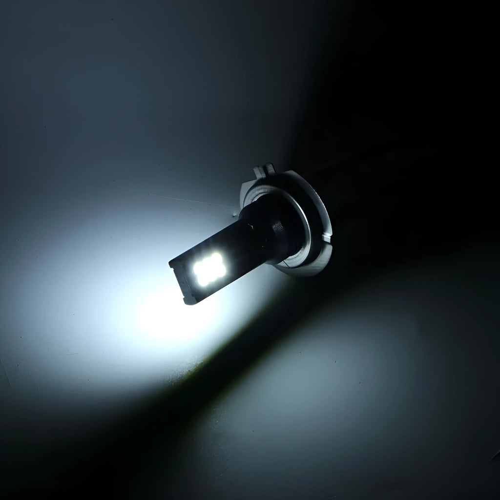Close-up of an H7 LED fog light bulb with aluminium housing and multiple small LED chips visible.