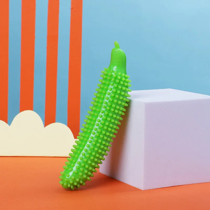 Green cucumber-shaped dog chew toy with a squeaker on a white background