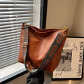 Retro bucket bag with wide shoulder strap, solid colour in beige, shown from front angle