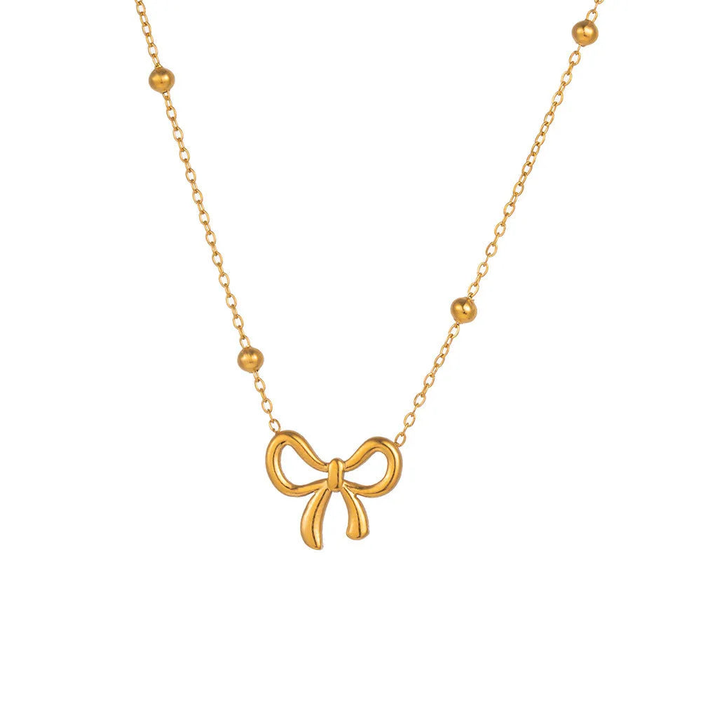 Gold electroplated titanium steel bow necklace with cross chain design showing adjustable length mechanism