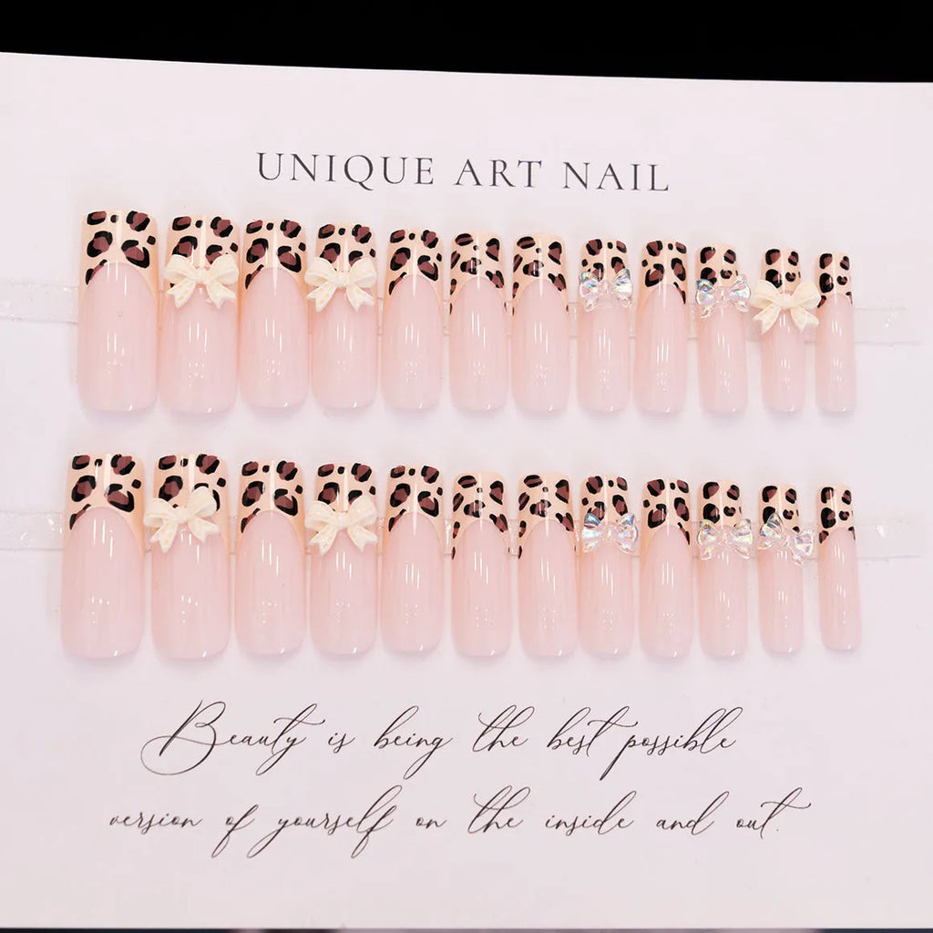 Leopard print pattern false nails with butterfly charms from a plastic nail art kit.