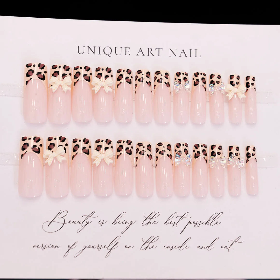 Leopard print pattern false nails with butterfly charms from a plastic nail art kit.