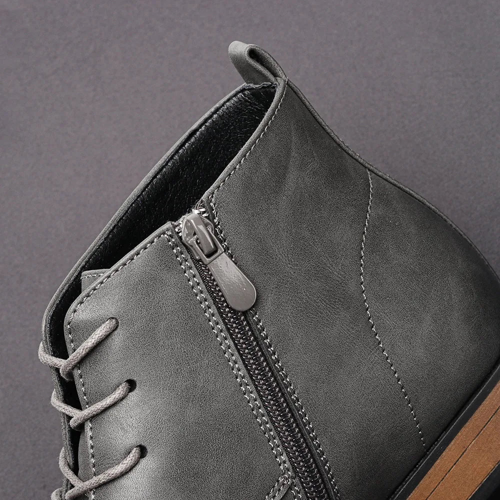 Men's brown Chelsea ankle boots with a visible side zipper on a wooden sole.